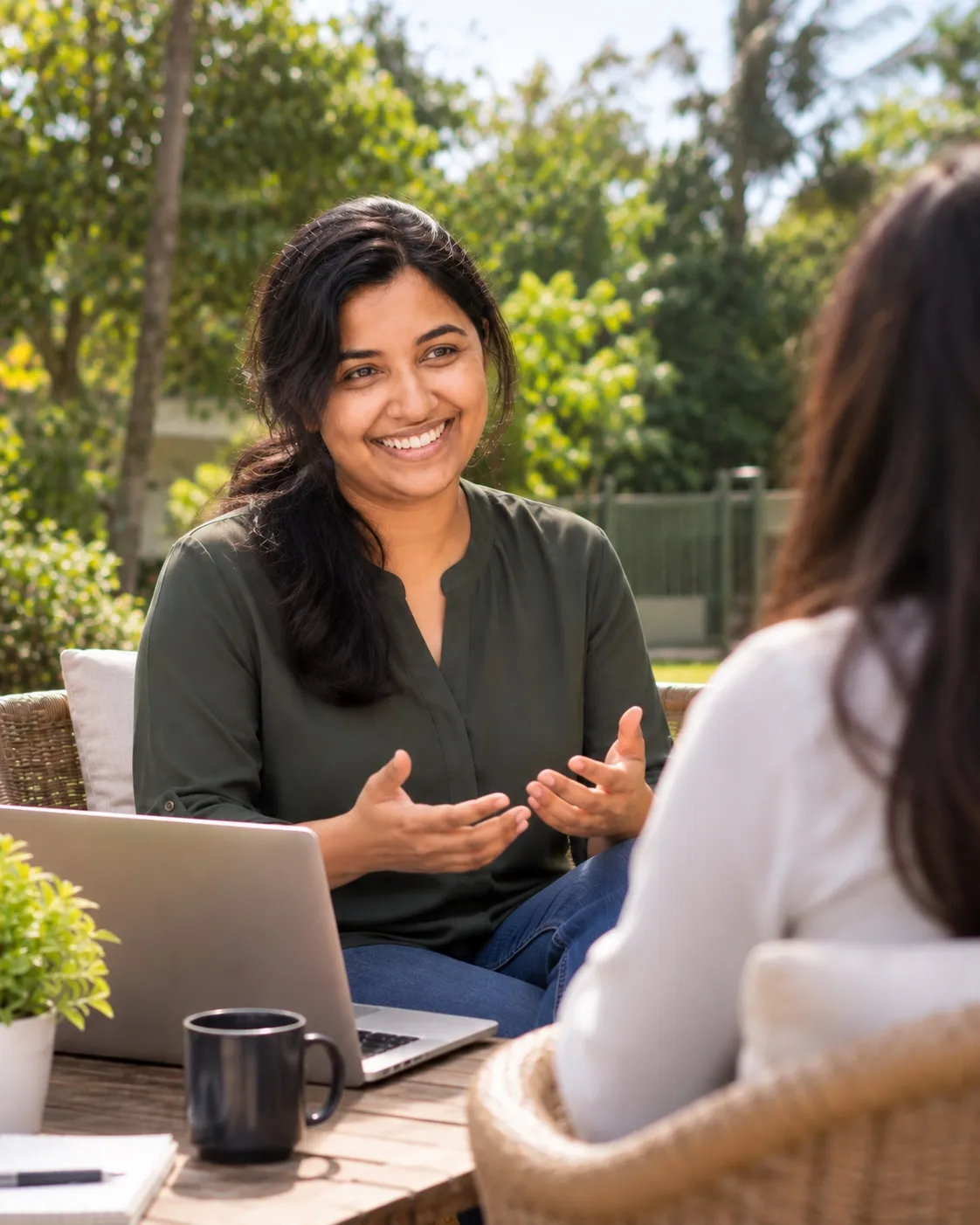 Anjala Jose talking with a client in a garden